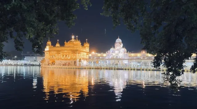 The Harmandir Sahib, the Golden Temple at Amritsar, lit at night and reflected in the sarovar